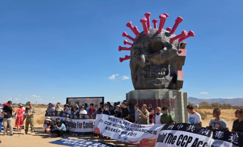 Deelnemers aan een cross-country autorally staan voor het CCP Virus-beeld in Liberty Sculpture Park in het Mojavewoestijnstadje Yermo, Californië, op 6 september 2025. Met dank aan Chen Weiming.
