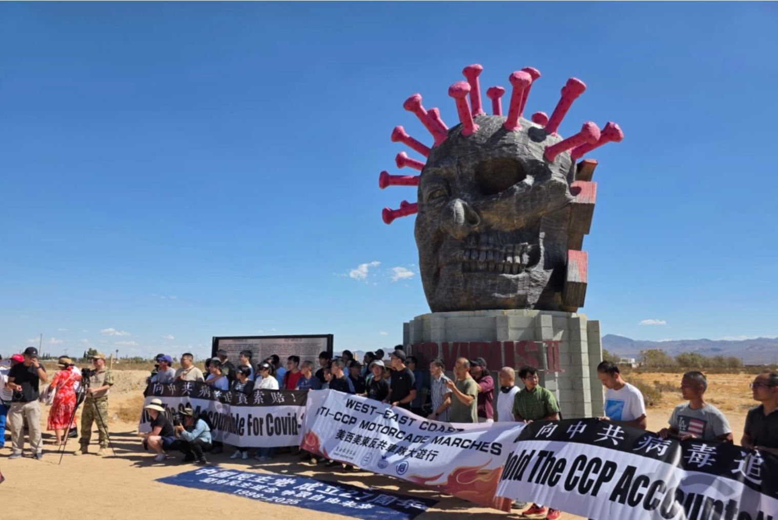 Deelnemers aan een cross-country autorally staan voor het CCP Virus-beeld in Liberty Sculpture Park in het Mojavewoestijnstadje Yermo, Californië, op 6 september 2025. Met dank aan Chen Weiming.